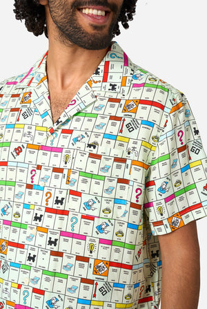 Person wearing a shirt with a colorful Monopoly pattern resembling a board game design.