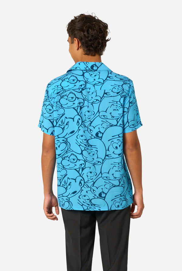 Person wearing a blue Smurfs patterned shirt with black pants on a white background. View from the back