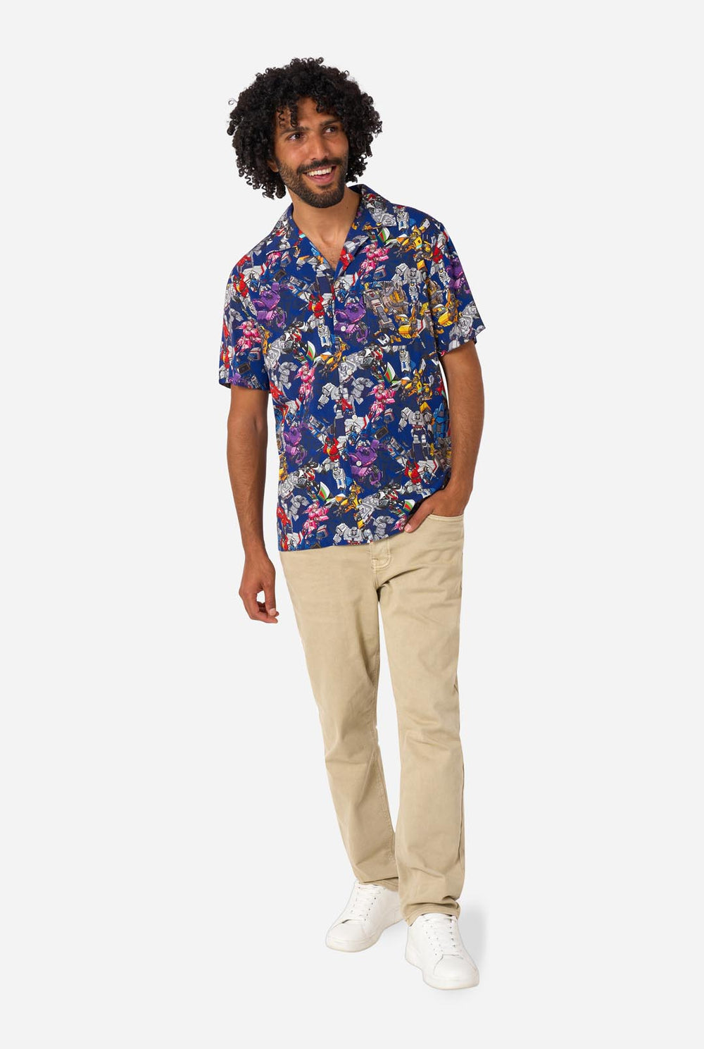 Man wearing a colorful Transformers patterned shirt on a white background