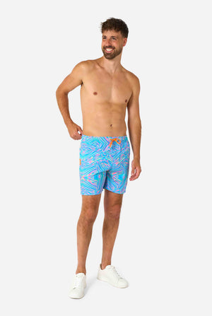 Man wearing colorful Holoperfect swim shorts on a white background. Full body image