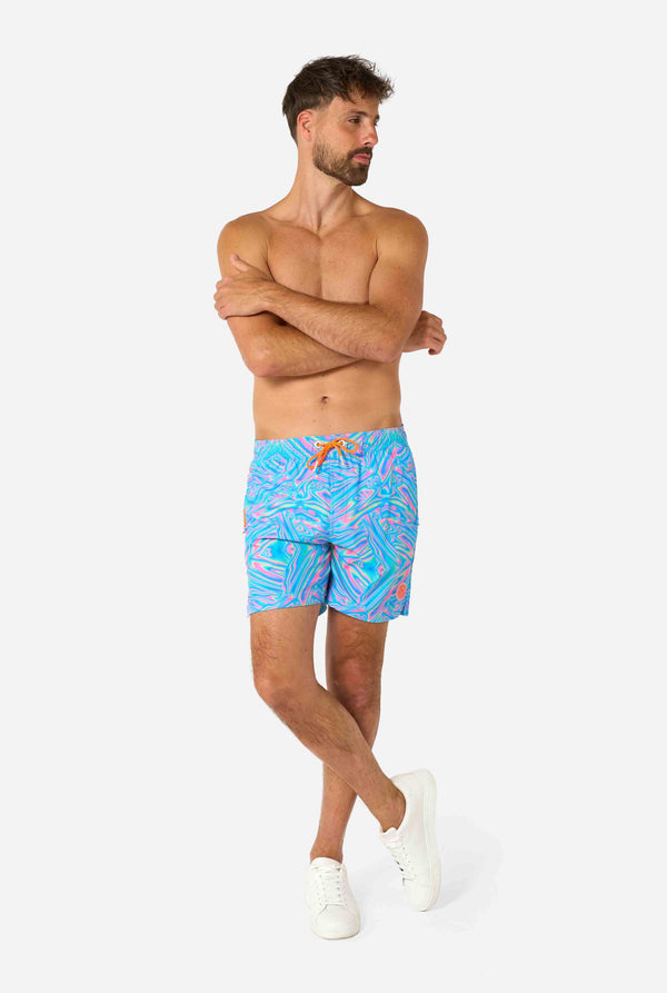 Man wearing colorful Holoperfect swim shorts on a white background. Full body image