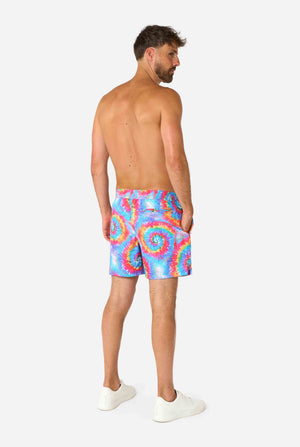 Man wearing colorful tie-dye swim shorts on a white background. View from the back