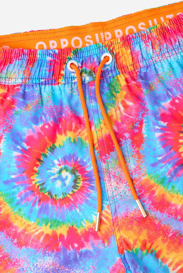 Colorful tie-dye shorts with a brand logo on an orange background