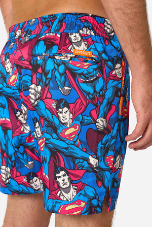 Superman-themed swim shorts with a visible brand logo on a white background