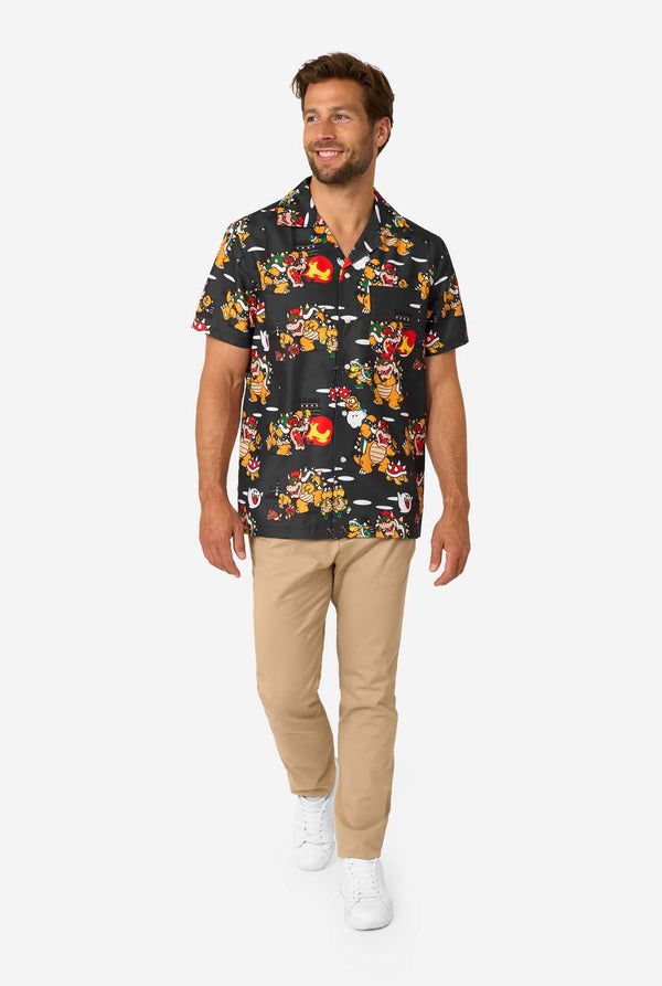 Man wearing a patterned Bowser shirt and beige pants on a white background