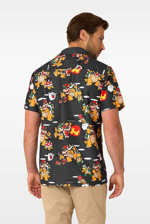 Man wearing a black Hawaiian shirt with colorful Bowser character print on a white background