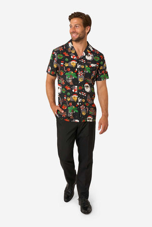 Man wearing a colorful patterned shirt and black pants on a white background