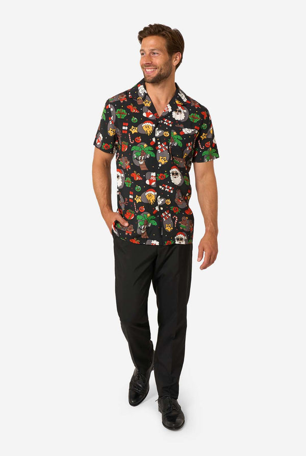 Man wearing a colorful patterned shirt and black pants on a white background