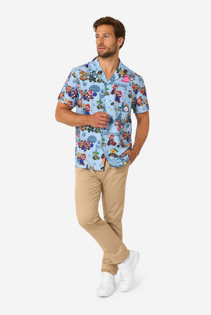 Man wearing a colorful patterned Mario shirt with beige pants on a white background