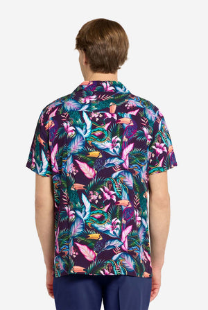 Person wearing a colorful tropical patterned shirt on a white background. View from the back