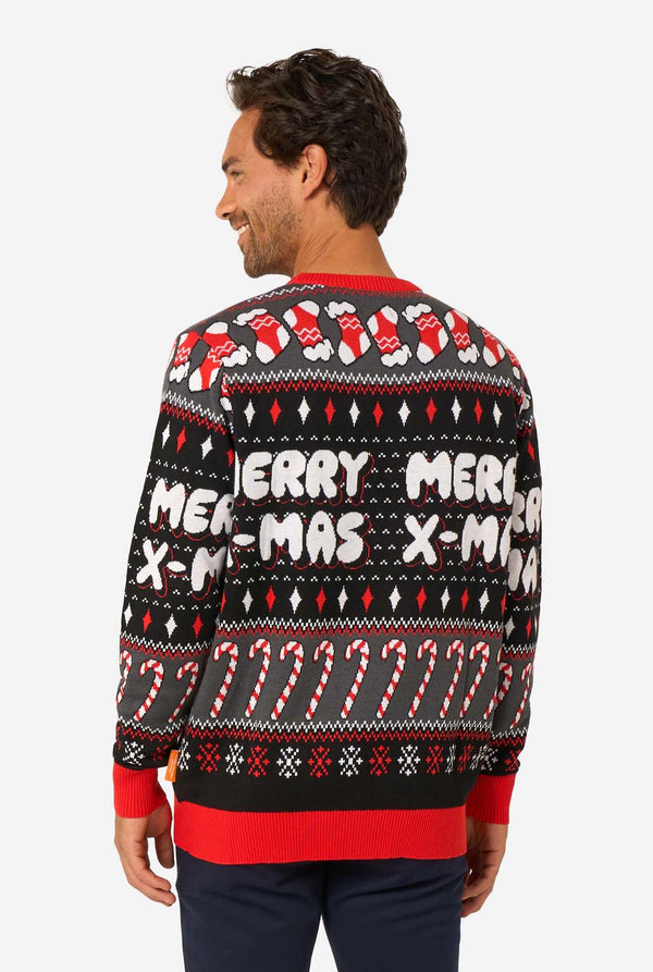 Man wearing a festive Christmas sweater with candy cane and stocking patterns. View from the back