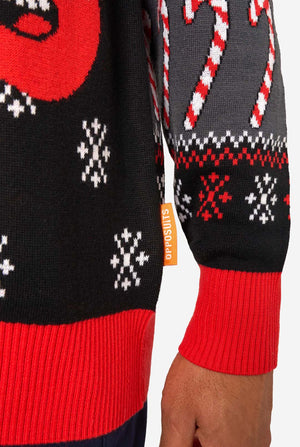 Close-up of a festive sweater with candy cane and snowflake patterns on a white background.