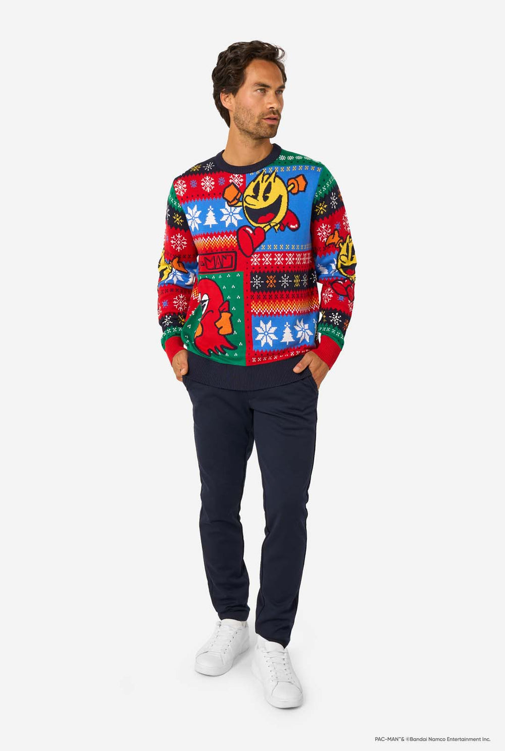 Man wearing a colorful sweater with Pac-Man character designs on a white background