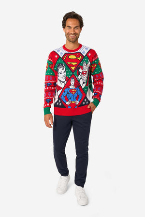 Man wearing a colorful Superman-themed Christmas sweater on a white background. Full body image