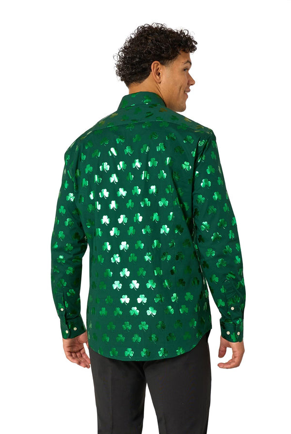 Person wearing a green shirt with shamrock pattern on a white background. View from the back