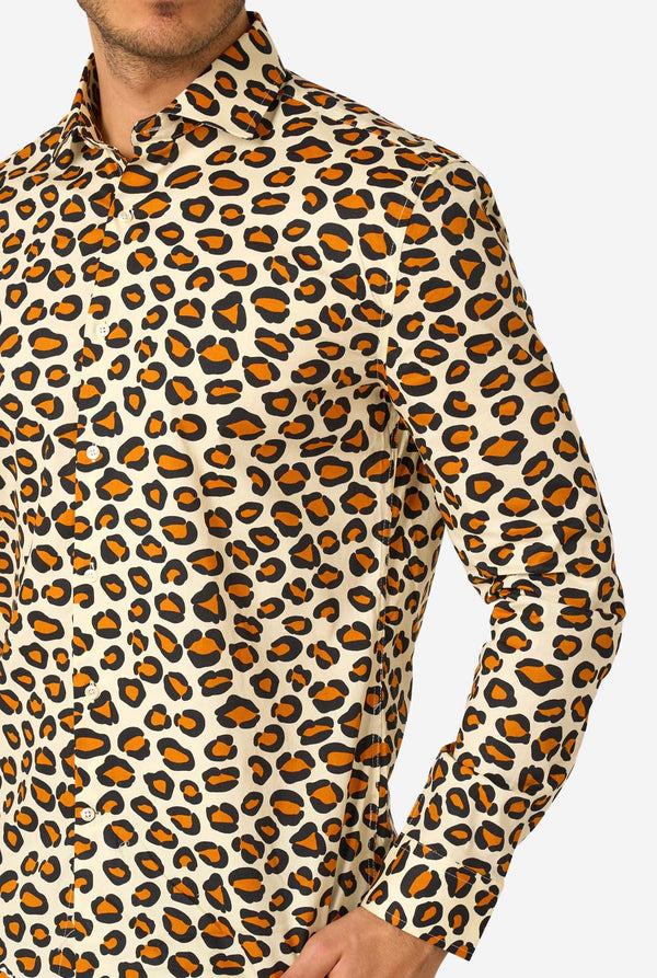 Image of a man wearing a beige shirt covered with panther spots. Chest close-up.