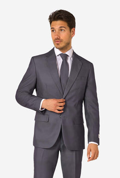 Man wearing a gray suit with a white shirt and tie on a light gray background
