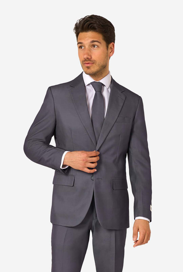 Man wearing a gray suit with a white shirt and tie on a light gray background