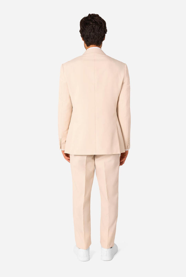Person wearing a sand colored suit standing against a white background. View from the back
