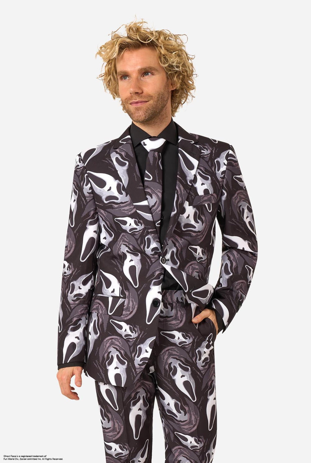 A man modeling a Ghostface-themed suit with a black, white, and gray mask pattern, a black shirt, a bow tie.