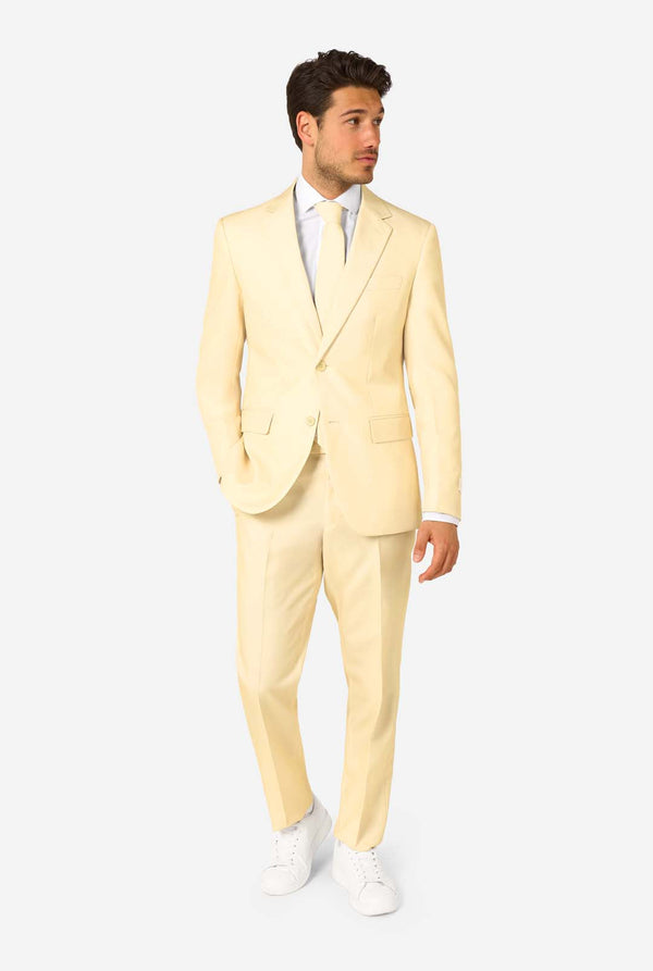 Man wearing a light yellow suit with a white shirt on a white background. Full body image