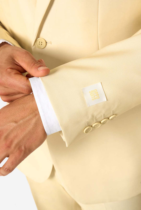 Close-up of a person adjusting the cuff of a light-colored suit jacket.