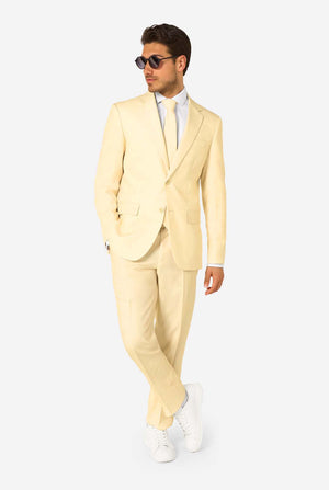 Man wearing a light yellow suit with sunglasses on a white background. Full body image
