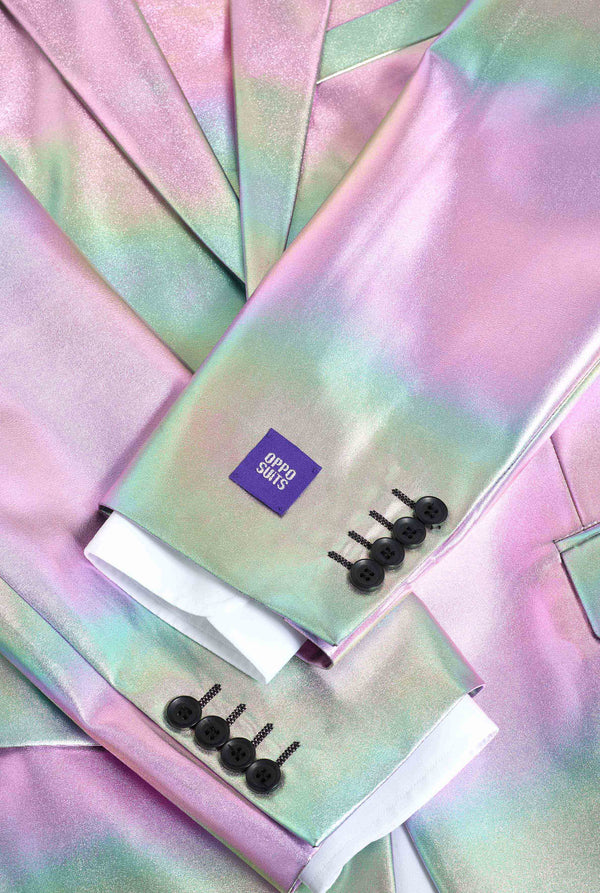 Iridescent fabric with a small purple label and black hair clips on a matching background.