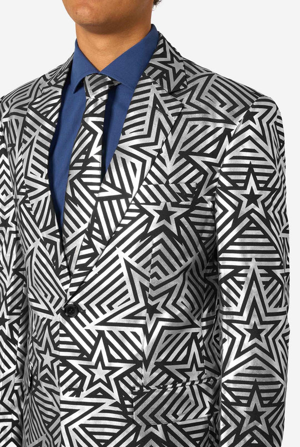 Person wearing a black and silver star patterned suit with a blue shirt and tie.