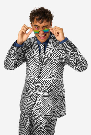 Person wearing a black and silver geometric patterned outfit with colorful sunglasses on a white background