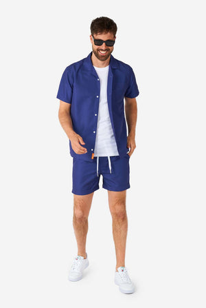 Man wearing blue summer set consisting of shirt and shorts, full body image