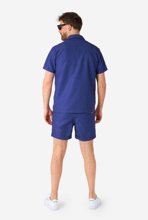 Man wearing blue summer set consisting of shirt and shorts, full body image view from the back