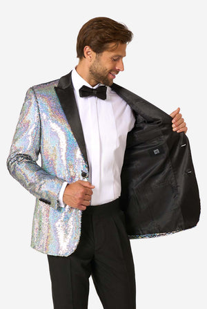 Man wearing a holographic sequin jacket over a black tuxedo on a white background
