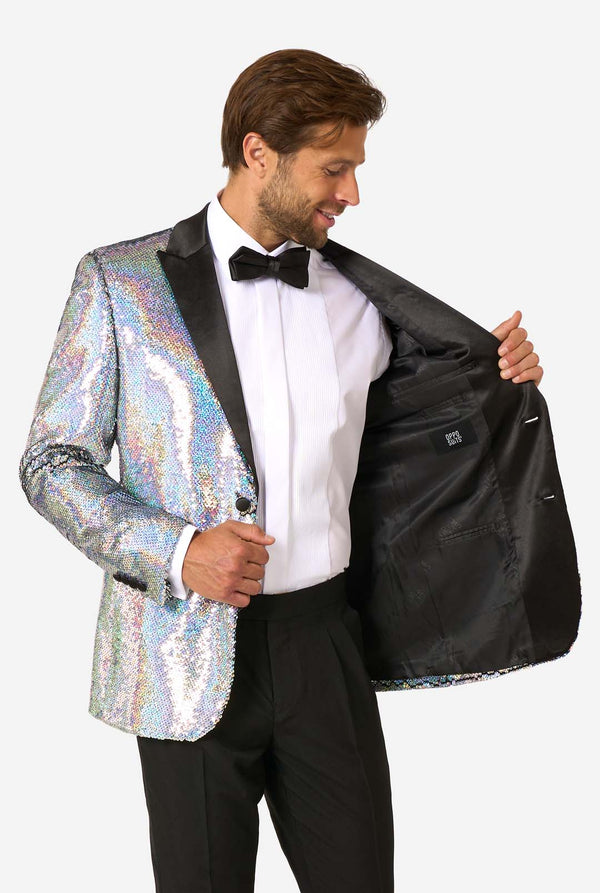 Man wearing a holographic sequin jacket over a black tuxedo on a white background