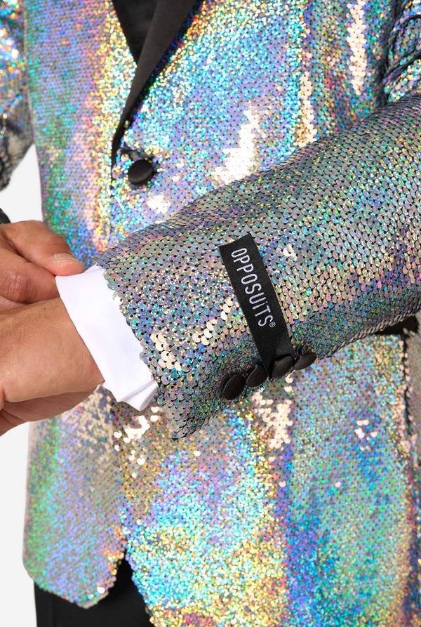 Close-up of a person wearing a shiny, holographic sequin jacket with 'Opposuits' label.