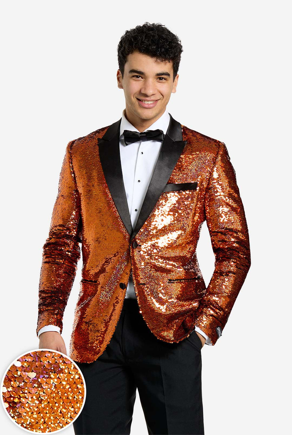 Man wearing a orange sequin tuxedo jacket with a black bow tie on a white background