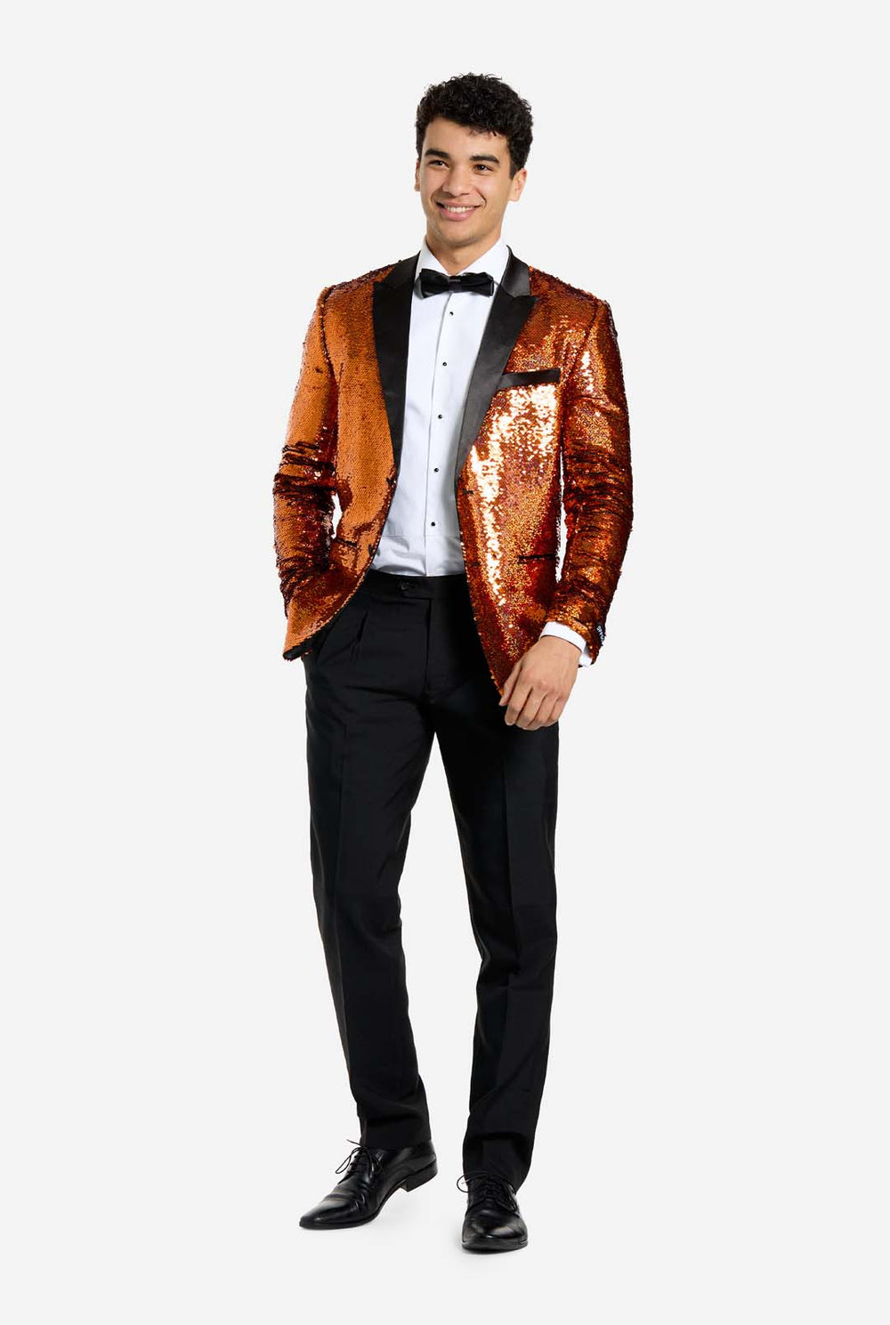 Man wearing a orange sequin tuxedo jacket with a black bow tie on a white background