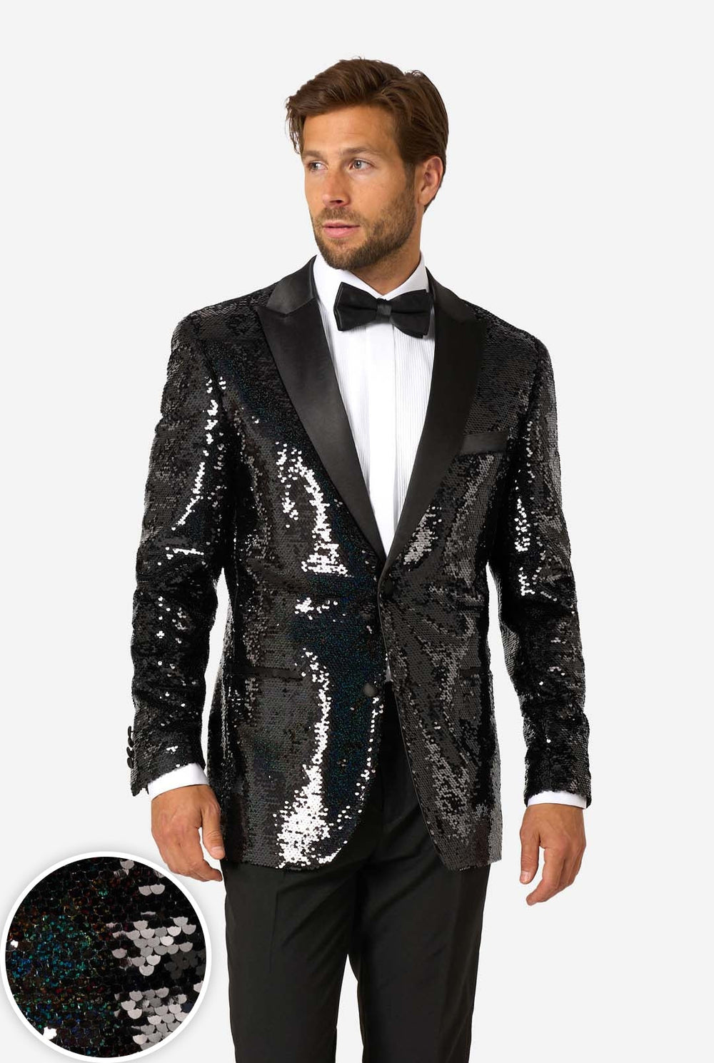 A man modeling a black sequined tuxedo jacket with black satin lapels, worn over a white dress shirt and black bow tie, against a light gray studio background. A circular inset at the lower left shows a close-up of the black sequin texture.