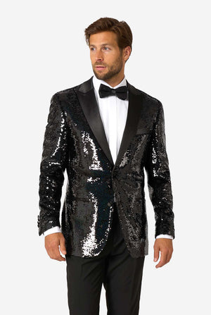 Man wearing a black sequin tuxedo with a bow tie on a white background
