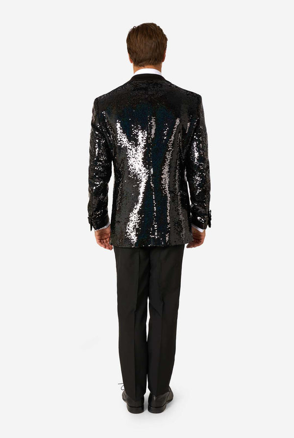 Man wearing a black sequin jacket and black pants on a white background