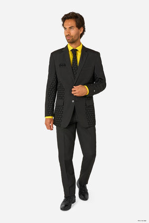 Man wearing a black Batman suit with yellow shirt on a white background. Full body image