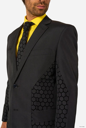 Man wearing a black Batman suit with geometric patterned lapels and a yellow shirt.