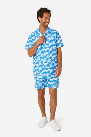 Man wearing a blue and white patterned shirt and shorts on a white background. Full body image