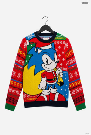 A festive Christmas crewneck sweater featuring Sonic the Hedgehog, hanging on a black hanger against a light gray background. The design features Sonic in Santa's outfit on a yellow crescent moon, with red and green patterned sleeves and 'HO HO HO' text.