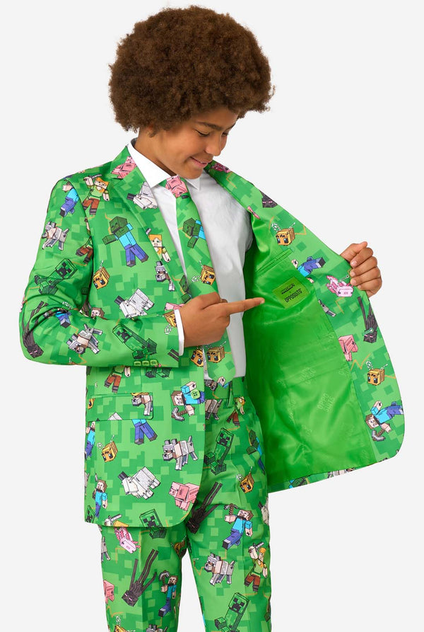 Child wearing a green suit with Minecraft character patterns on a white background