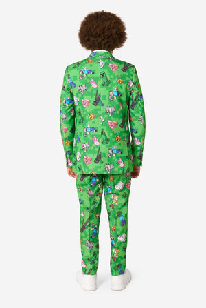 Person wearing a green onesie with Minecraft prints on a white background