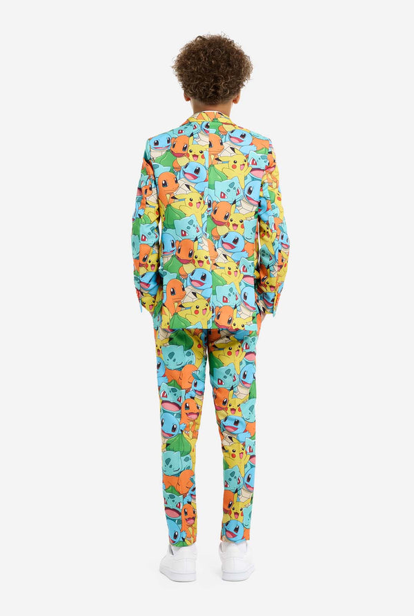 Teen wearing formal multi color suit with all-over Pokemon print. The suit contains the characters Pikachu, Bulbasaur, Charmander and Squirtle. View from the back.