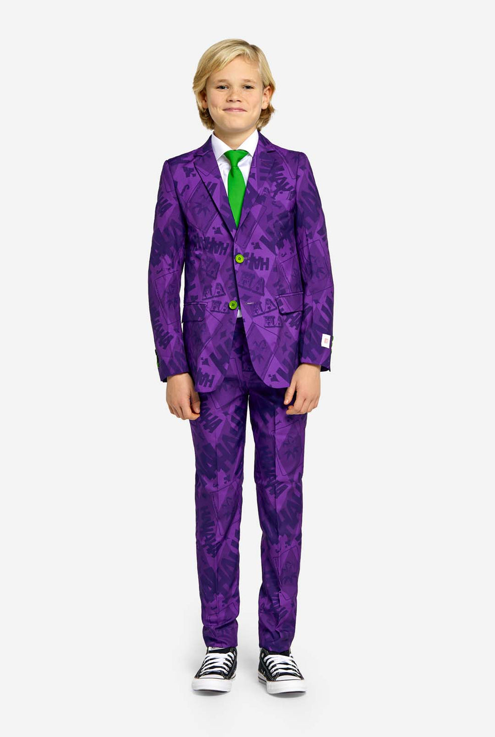Teen wearing purple teen boys suit with a The Joker theme and green buttons. Further he is wearing a green tie and a white shirt. Hands in pockets of pants.