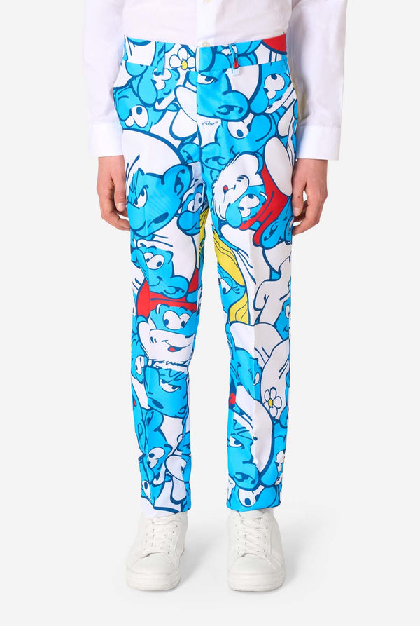 Teen boy wearing a vibrant Smurfs kids suit with colorful cartoon character prints in blue, red, yellow, and white, paired with a matching tie and white shirt, smiling against a plain background. Pants close up.