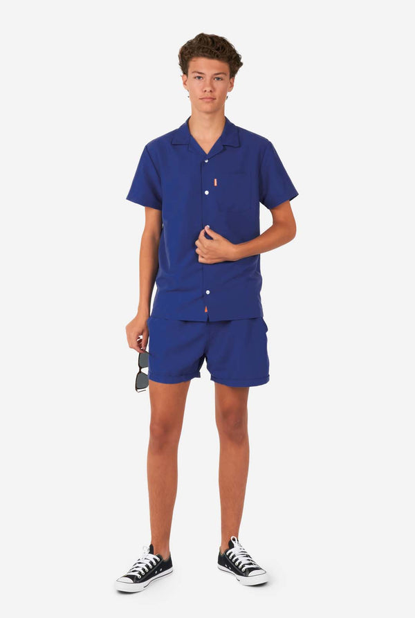 Teen wearing dark blue summer set, consisting of shorts and shirt, full body image